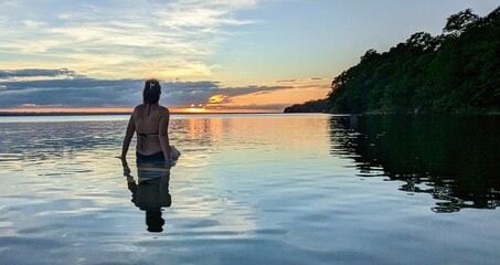 femme coucher de soleil flottant sur l'eau.