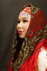 a girl in a Chuvash dress and with a red scarf on a dark background