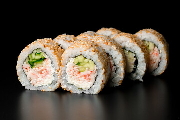 tasty sushi rolls california with snow crab meat garnished sesame seeds on dark background.