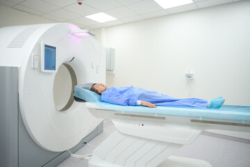 Woman lies on a special mobile surface of MRI machine
