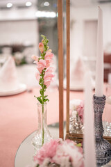 Centerpiece made of green leaves and fresh flowers stands on the dinner table. Wedding day. Fresh flowers decorations. Peony arrangements.