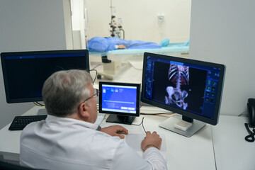 Male diagnostician performs a CT scan using modern equipment