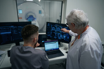Doctors, man and a woman, are looking through MRI images