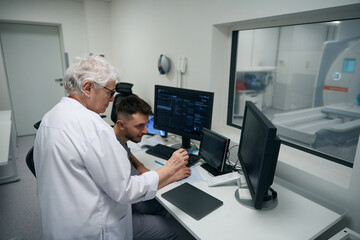 Colleagues diagnosticians perform MRI of the brain