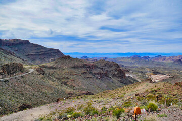 Fototapeta na wymiar View from the Sitgreaves Pass in the Black Mountains, on the Oatman Highway between Kingman and Oatman, Arizona, USA. In the foreground some memorials, in the background the silver mine of Oatman