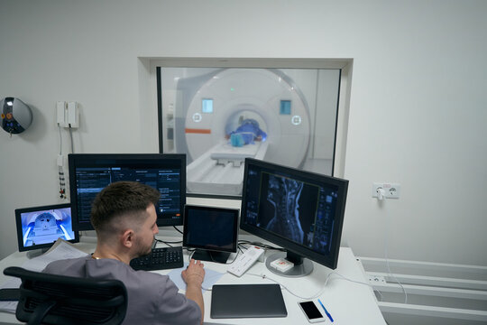 Young doctor conducts MRI diagnostics in a modern clinic