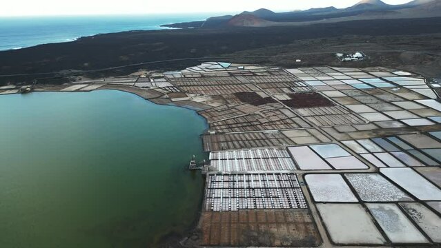 Spain - Drone aerial view of  Janubio salt flats mines (Playa del Janubio) in Lanzarote  are the largest in the Canary Islands - salt production, pools of sea water dry in the sun, tourist attraction