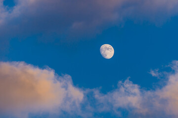 Naklejka na ściany i meble Bright moon in blue sky among clouds