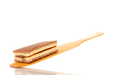 One mini cocoa biscuit on a wooden spoon, macro, isolated on white background.