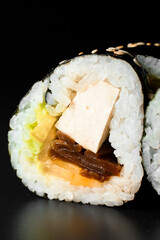 Close-up of filling of sushi roll with smoked eel, avocado, cream cheese and unagi sauce. Sushi menu.