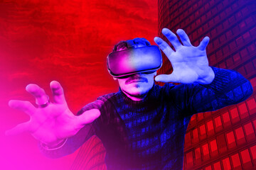 Young man is using virtual reality viewer. Modern man portrait with trendy look and bright colors. - 563125695