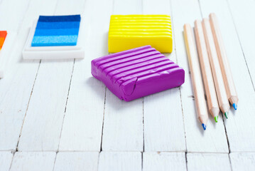 plasticine blocks, ink pads and pencils, brushes on white wood table
