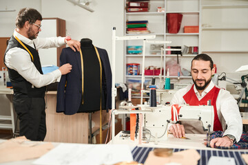 Two couturiers working together in clothing atelier