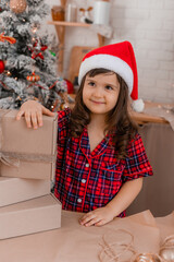 a happy little girl at home in the kitchen is packing Christmas presents in crab boxes. new year's sale