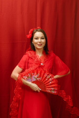 a girl in a red dress on a red background with a red fan