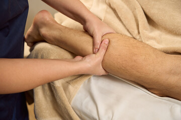 Specialist works with the calf muscle of the client