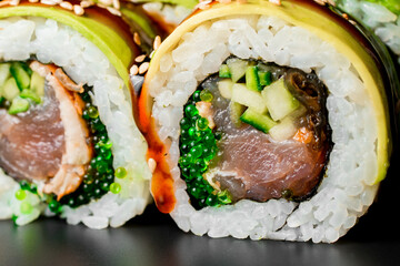Close-up of filling of green dragon sushi rolls with salmon, avocado, cucumber and green caviar.