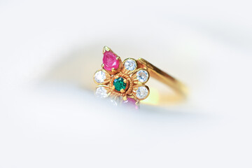 Golden Indian style wedding ring wrapped in white Satin fabric.