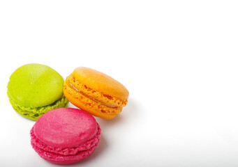trois macarons en couleurs orange, vert et rose