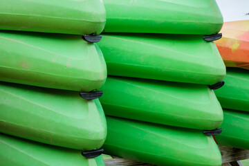 Close-up of many vibrant green kayaks stacked upside down.