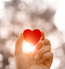 red heart in hand and beautiful sunset. Love, and Valentine's Day background 