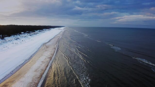 Aerial view of the Baltic Sea from a bird's eye. A snowy beach. Aerial drone footage of Baltic sea during winter. European nature. Latvian sea coast. High quality 4k ProRes footage