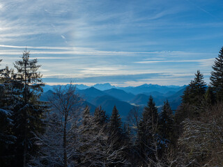 Lengries, Germany - December 28th 2023: Panoramic view over a forest towards alpine valleys and mountains