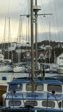 Verticel Timelapse of a small marina with boats on the coast of western Norway
