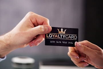 Businessman's Hand Giving Loyalty Card