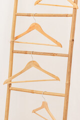 Des cintres suspendus sur une échelle en bois