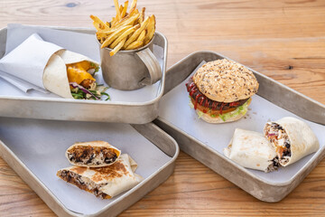 Set of different fast food snacks from burger burrito wrap and fried potatoes.