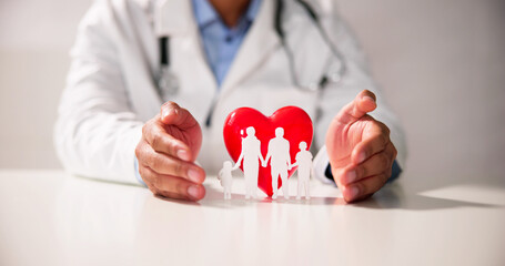 Doctor's Hand Protecting Red Heart With Family Figure