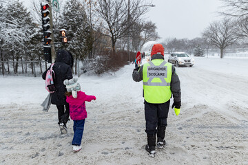 Brigadier scolaire faisant son travail pendant une averse de neige