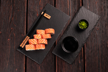 Sushi roll philadelphia with salmon and cucumber and cream cheese on black background top view. Sushi menu. Japanese food concept