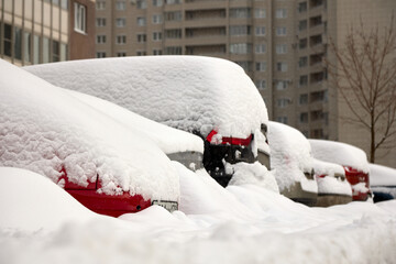 city car under snow, roadside a lot of snow on city streets.