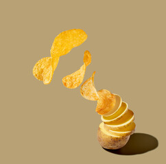 Potato slices and chips levitating on brown pastel background