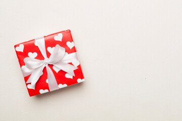 Gift box with hearts on concrete background, top view
