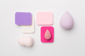 Beauty blenders on color background, top view