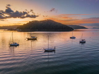 Aerial sunrise waterscape with boats and scattered clouds