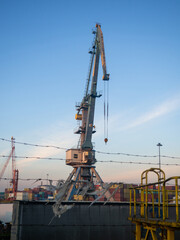 Fototapeta na wymiar Loading port crane. Loading cargo. Maritime business. Industry. High crane on the sea. Port area