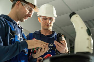 Technicians work with motherboard and try to connect wires to plug for charging EV on stations....