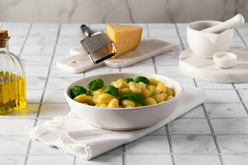 Italian gnocchi with basil on a white kitchen table