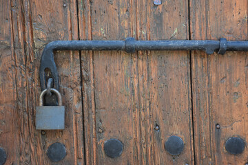 Old rusty lock hook and padlock on wooden door. Old rustic wooden door with padlock vintage concept