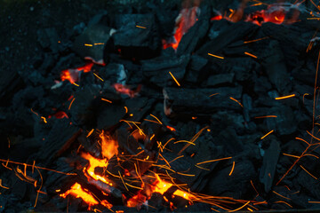 Coals with sparks in a huge old metal grill