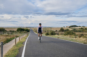 Obraz premium Man riding on a gravel bike on the road at sunset.Empty city road. Sports motivation.Murcia region in Spain