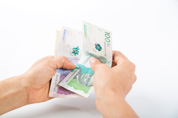 a person checking Colombian banknotes in his hands