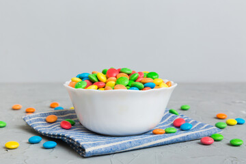 Multicolored candies in a bowl on a colored background. birthday and holiday concept. Top view with copy space