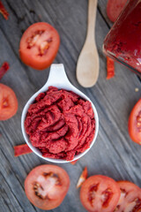 Traditional turkish tomato paste in bowl or spoon with fresh tomatoes on wooden table, homemade healthy food
