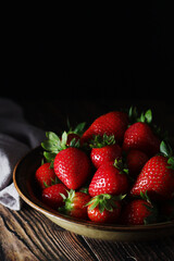 A bowl with ripe bright strawberry in rustic style