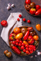The harvest of assorted tomatoes. Colorful organic tomatoes on a large dish. Tomatoes different varieties. Top view